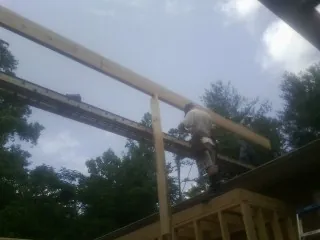 Carpenter setting a ridge beam over a new addition frame — Ice Dam Removal by Roofing Brothers in Idaho City