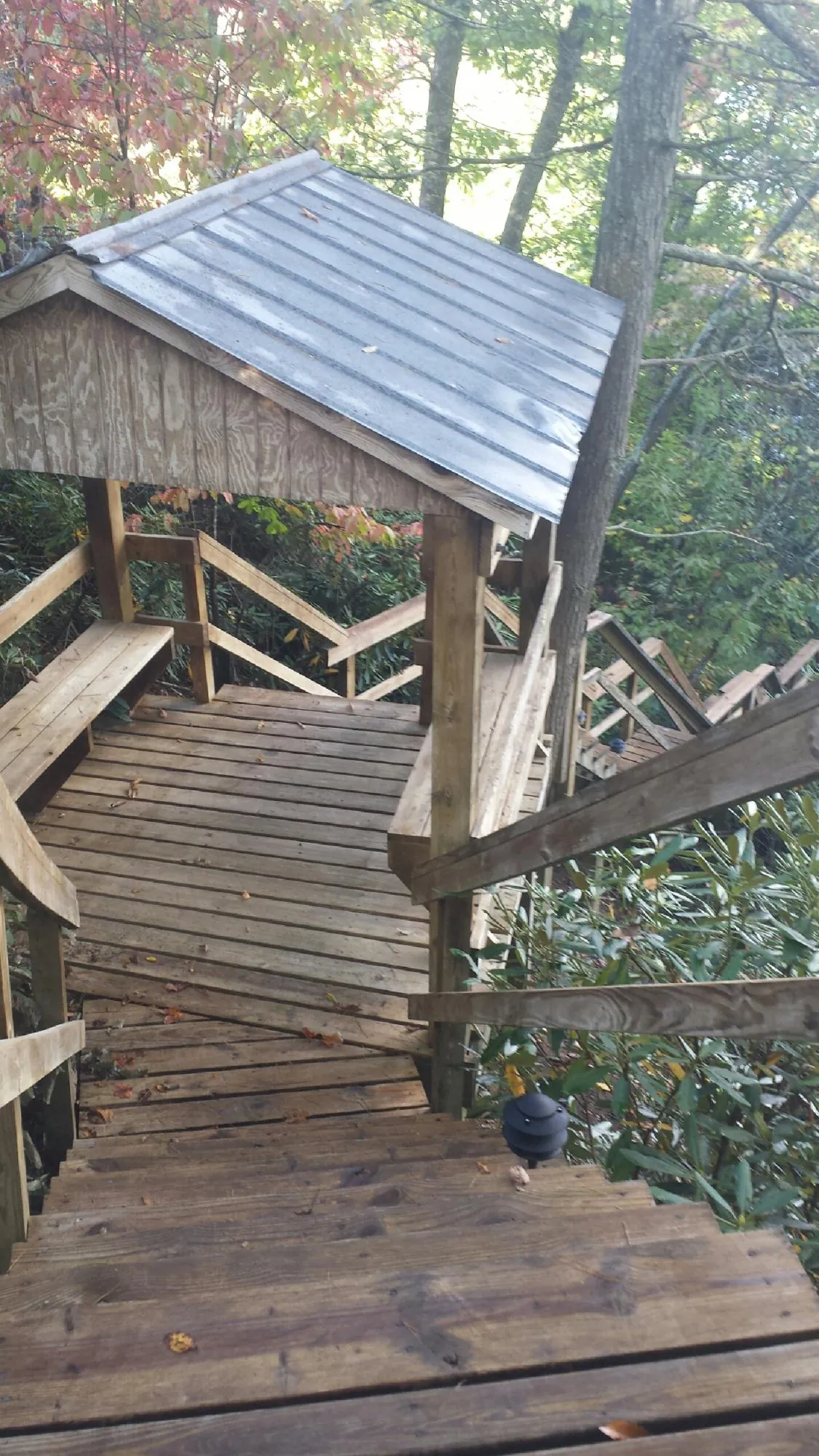 Metal roofed shelter over wooden steps on a wooded walkway — Skylight Repair & Installation work by our crew in Idaho City